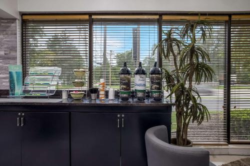 un bar avec des bouteilles d'alcool sur un comptoir avec une plante dans l'établissement Quality Inn Toledo Westgate, à Toledo