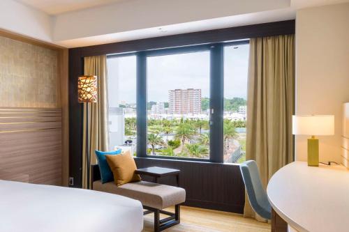 a hotel room with a bed and a window at DoubleTree by Hilton Okinawa Chatan Resort in Chatan