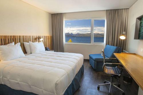 a hotel room with a bed and a desk and a window at Hampton By Hilton Bariloche in San Carlos de Bariloche