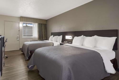 Habitación de hotel con 2 camas y almohadas blancas en Quality Inn Charleston - West Ashley, en Charleston