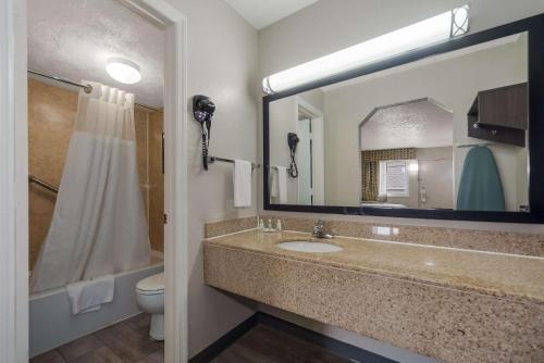 a bathroom with a sink and a toilet and a mirror at Quality Inn Charleston - West Ashley in Charleston