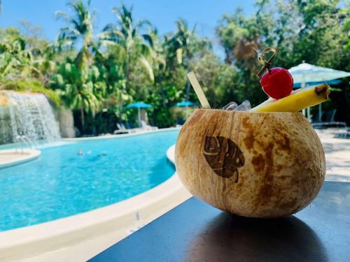 a coconut fruit with a cherry and a banana next to a swimming pool at Baker's Cay Resort Key Largo, Curio Collection By Hilton in Key Largo