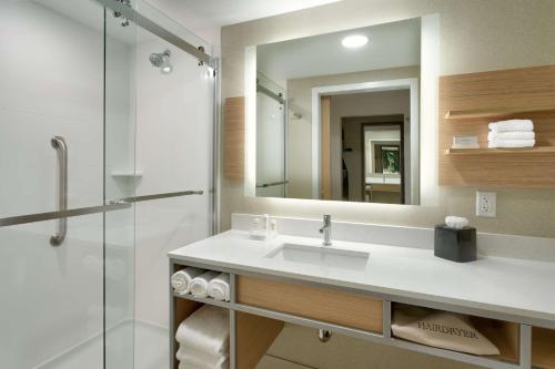 Hilton Garden Inn Lehi في ليهي: حمام مع حوض ومرآة