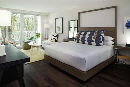 ein Schlafzimmer mit einem großen Bett und ein Wohnzimmer in der Unterkunft Baker's Cay Resort Key Largo, Curio Collection By Hilton in Key Largo