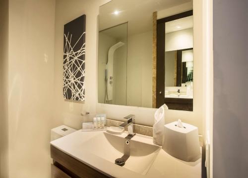 a white bathroom with a sink and a mirror at Hampton by Hilton David, Panamá in David