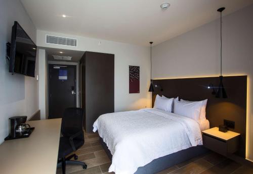 a hotel room with a bed and a desk and a desk at Hampton by Hilton David, Panamá in David