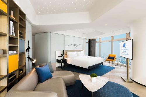 um quarto de hotel com uma cama e um sofá em Doubletree by Hilton Foshan Nanhai-Free Canton Fair Shuttle Bus em Foshan