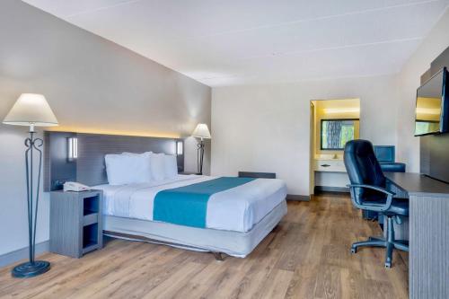 a hotel room with a bed and a desk and chair at Motel 6 Morgantown in Morgantown
