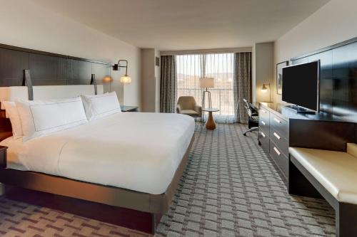 a hotel room with a bed and a flat screen tv at The Chattanoogan Hotel, Curio Collection By Hilton in Chattanooga