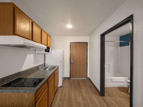 a small kitchen with a sink and a refrigerator at WoodSpring Suites Dallas Rockwall in Rockwall