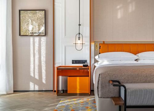 a bedroom with a bed and a nightstand with a table at Canopy by Hilton Hangzhou West Lake in Hangzhou