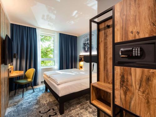 een hotelkamer met een bed en een bureau bij ibis Styles Hamburg Barmbek in Hamburg