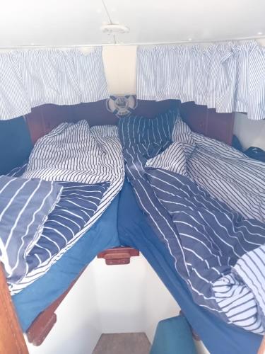 ein Bett mit blauer und weißer Bettwäsche darauf in der Unterkunft The Boat in Lagos