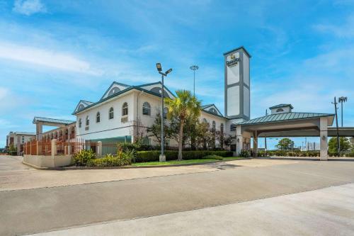 a large building with a clock tower in front of it at Quality Inn & Suites Houston Northwest - Cypress in Houston