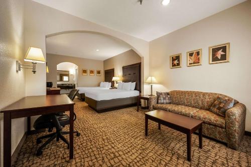 Großes Hotelzimmer mit einem Bett und einem Schreibtisch. in der Unterkunft Quality Inn & Suites in Houston