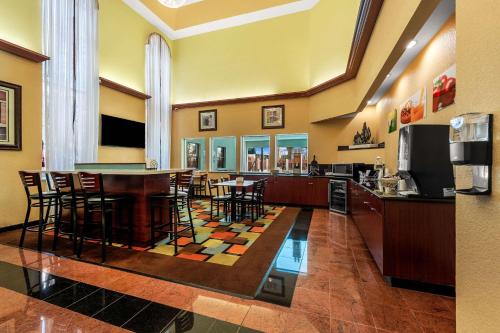 a lobby with a bar with chairs and a kitchen at Quality Inn & Suites Houston Northwest - Cypress in Houston