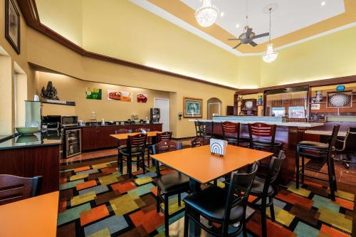 a restaurant with tables and chairs and a bar at Quality Inn & Suites Houston Northwest - Cypress in Houston