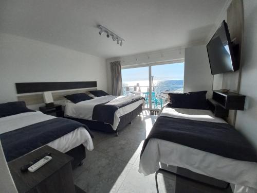 a hotel room with two beds and a television at Hotel Cocó Cochoa in Viña del Mar