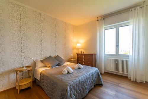 una camera da letto con un letto e due asciugamani di SkyAttic - 801 - CItyLife - 1 min Domodossola M5 a Milano