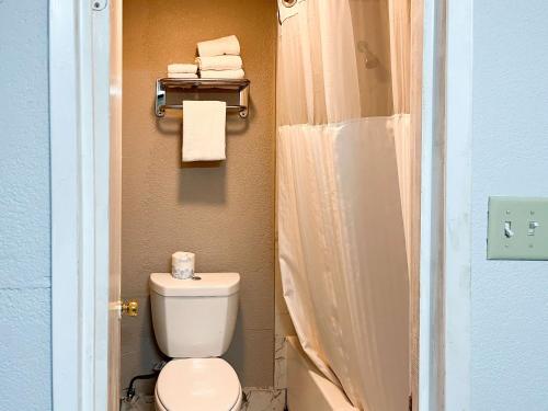 a bathroom with a toilet and a shower with towels at Studio 6 Suites Delano, CA in Delano