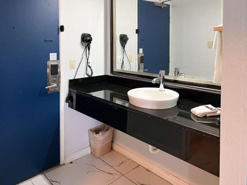 a bathroom with a sink and a mirror at Studio 6 Suites Delano, CA in Delano