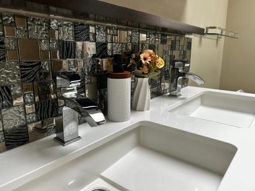 La salle de bains est pourvue d'un lavabo avec un vase de fleurs sur un comptoir. dans l'établissement Toronto central area double bed room, à Toronto