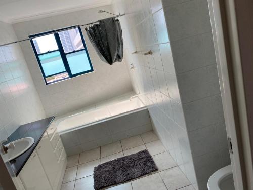 Sea View Full Apartment at Darwin City Heart في داروين: حمام أبيض مع حوض ومغسلة