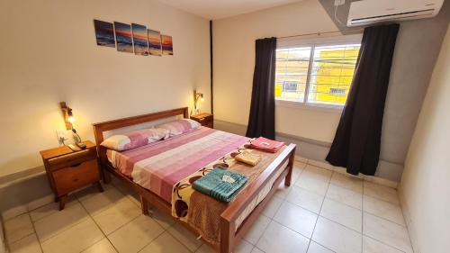 a bedroom with a bed with a table and a window at Departamentos San Pedro in San Pedro de Jujuy