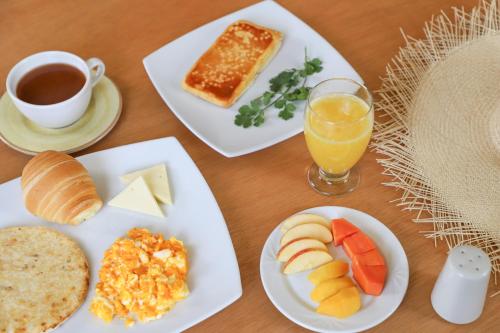 Hotel Casa Quintana في Aguadas: طاولة مع أطباق من الطعام وكأس من عصير البرتقال