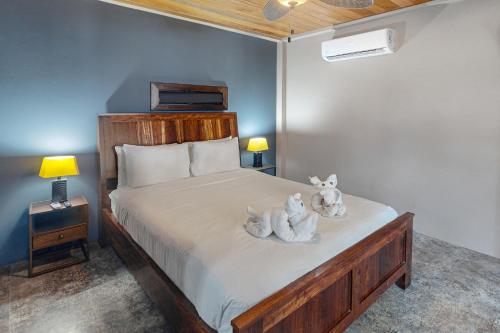 two stuffed animals sitting on a bed in a bedroom at Suite 1 at Island Pearl Gold Standard Certified in Caye Caulker