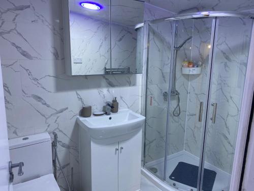 uma casa de banho branca com um chuveiro e um lavatório. em Calm house twin beds em Wyken