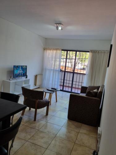 sala de estar con sofá, sillas y TV en Departamento excelente ubicación a 4 cuadras calle Aristides Villanueva en Mendoza