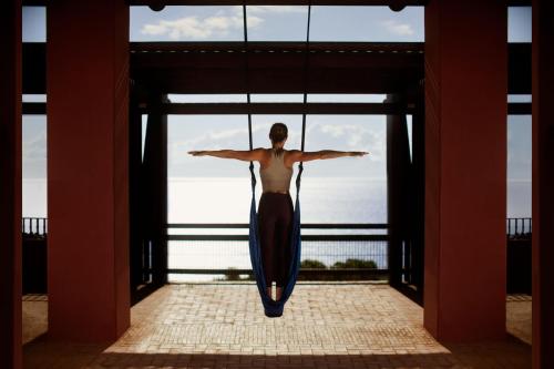 a woman walking in front of a window with her arms out at The Ritz-Carlton Tenerife, Abama in Guía de Isora