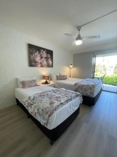 a bedroom with two beds and a window at Myuna Holiday Apartments in Noosa Heads