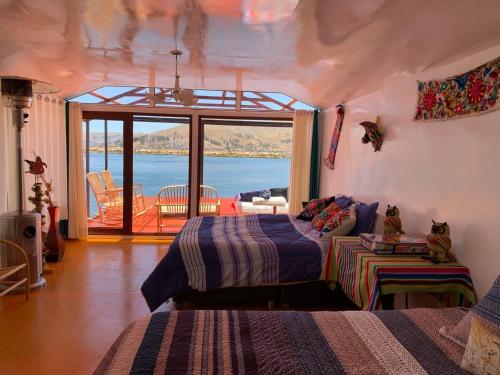 a bedroom with two beds and a view of the water at Uros Titicaca Mallku lodge in Puno