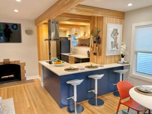 a kitchen with a counter with stools and a fireplace at Cabin Vibes Condo in North Capitol Hill in Seattle