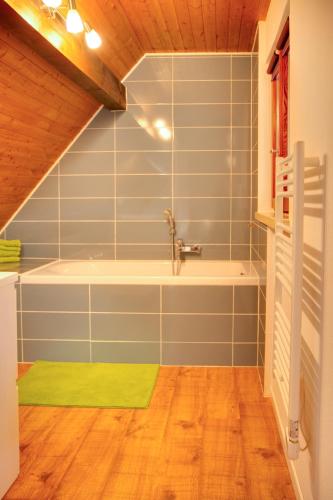 La salle de bains est pourvue d'une baignoire et d'un tapis vert. dans l'établissement La Parenthese, à Gertwiller