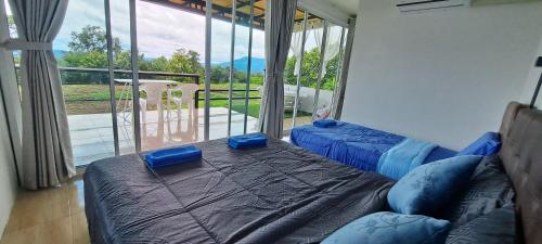 a bedroom with two beds and a large window at บ้านไร่ระเบียงฟ้า น้ำหนาว แคมป์ปิ้ง in Ban Phu Hi
