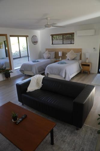 a living room with two beds and a couch at 'Stay in Carrara' A private guest suite not a share house in Gold Coast