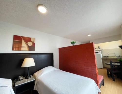 1 dormitorio con 2 camas y pared roja en Suites Havre, en Ciudad de México