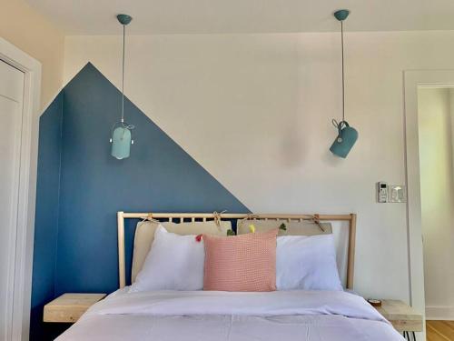 uma cama com uma parede de acento azul e duas luzes em Modern Amenities & Chic Design in Heart of Seattle em Seattle