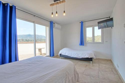 een slaapkamer met een bed en een groot raam bij Sublime Bastide vue exceptionnel au calme LE MAS DES FARACHES in Solliès-Toucas