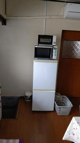 a microwave sitting on top of a white refrigerator at Akira Peak House annex in Nikko