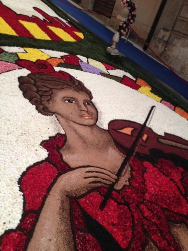 a painting of a woman holding a knife on a rug at La Perla Di Noto in Noto