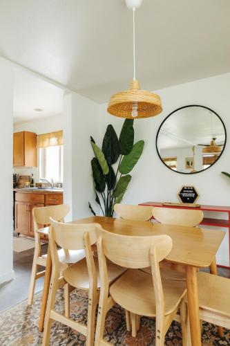 a dining room with a table and chairs and a mirror at Earthy Beach House in Kailua-Kona