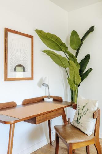 a table and a chair with a mirror and a plant at Earthy Beach House in Kailua-Kona