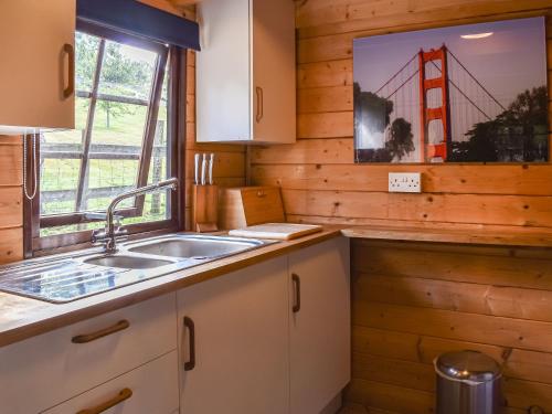 a kitchen with a sink and a window at Lekido in Hernhill