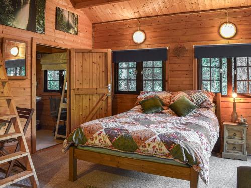 1 dormitorio con 1 cama en una cabaña de madera en Lekido, en Hernehill