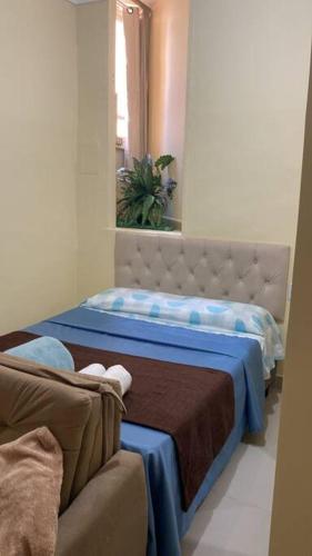 una camera da letto con un letto con lenzuola blu e uno specchio di Apartamento encantador 04 a Montes Claros