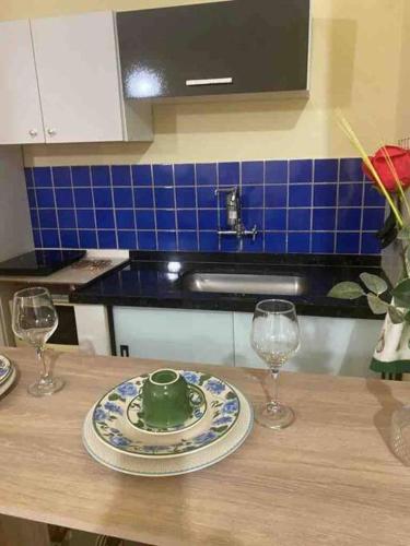 a table with a plate and two wine glasses at Apartamento encantador 04 in Montes Claros